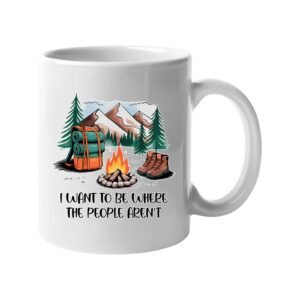 White mug with a campfire, backpack, boots and mountains with “I want to be where the people aren’t”