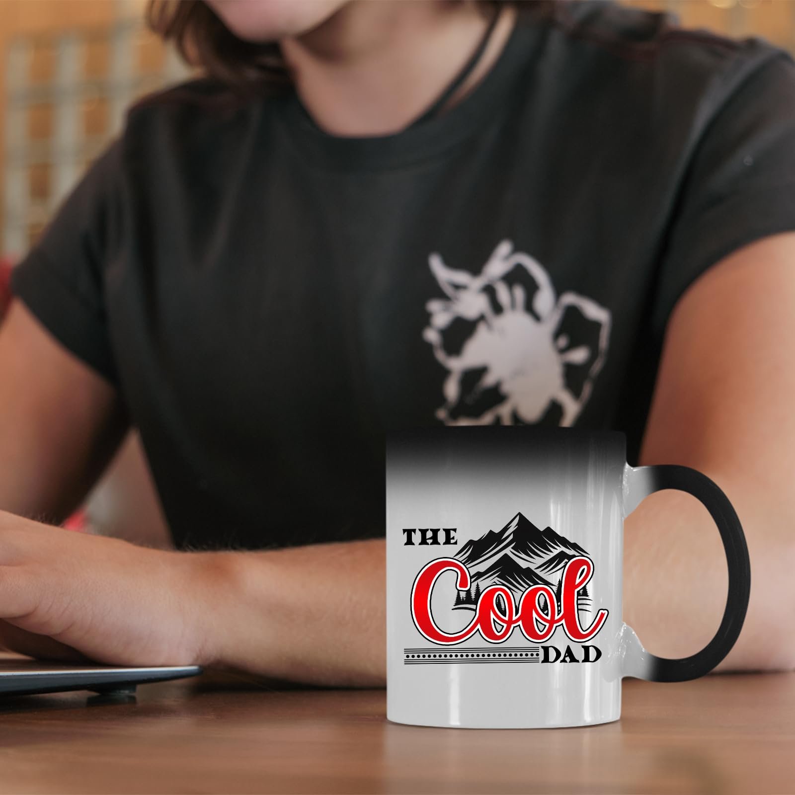 61efeasqcel.jpg The Cool Dad mountains colour changing mug on a desk beside a laptop