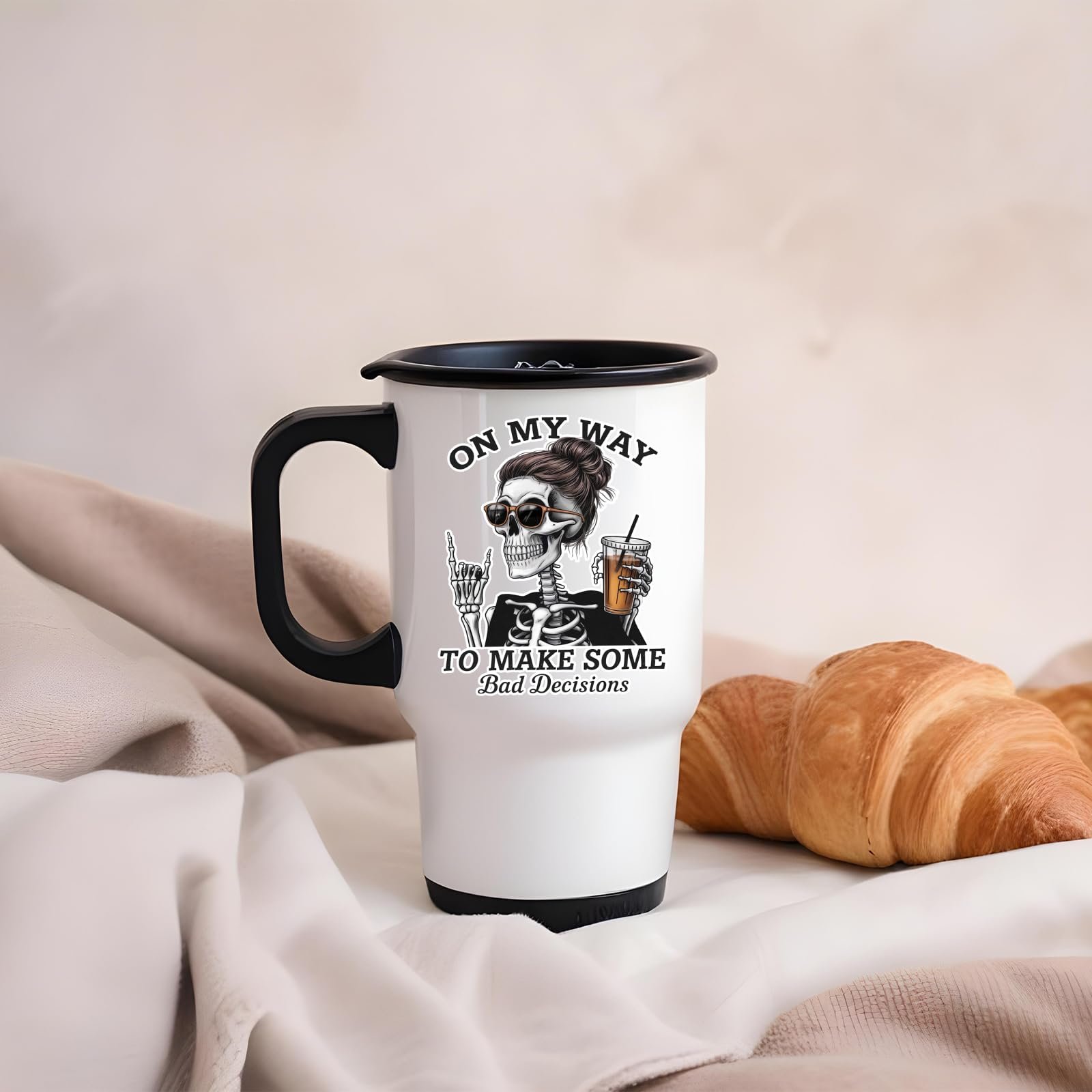 61qyyfog fl.jpg Bad Decisions skeleton travel mug on a soft blanket beside a croissant