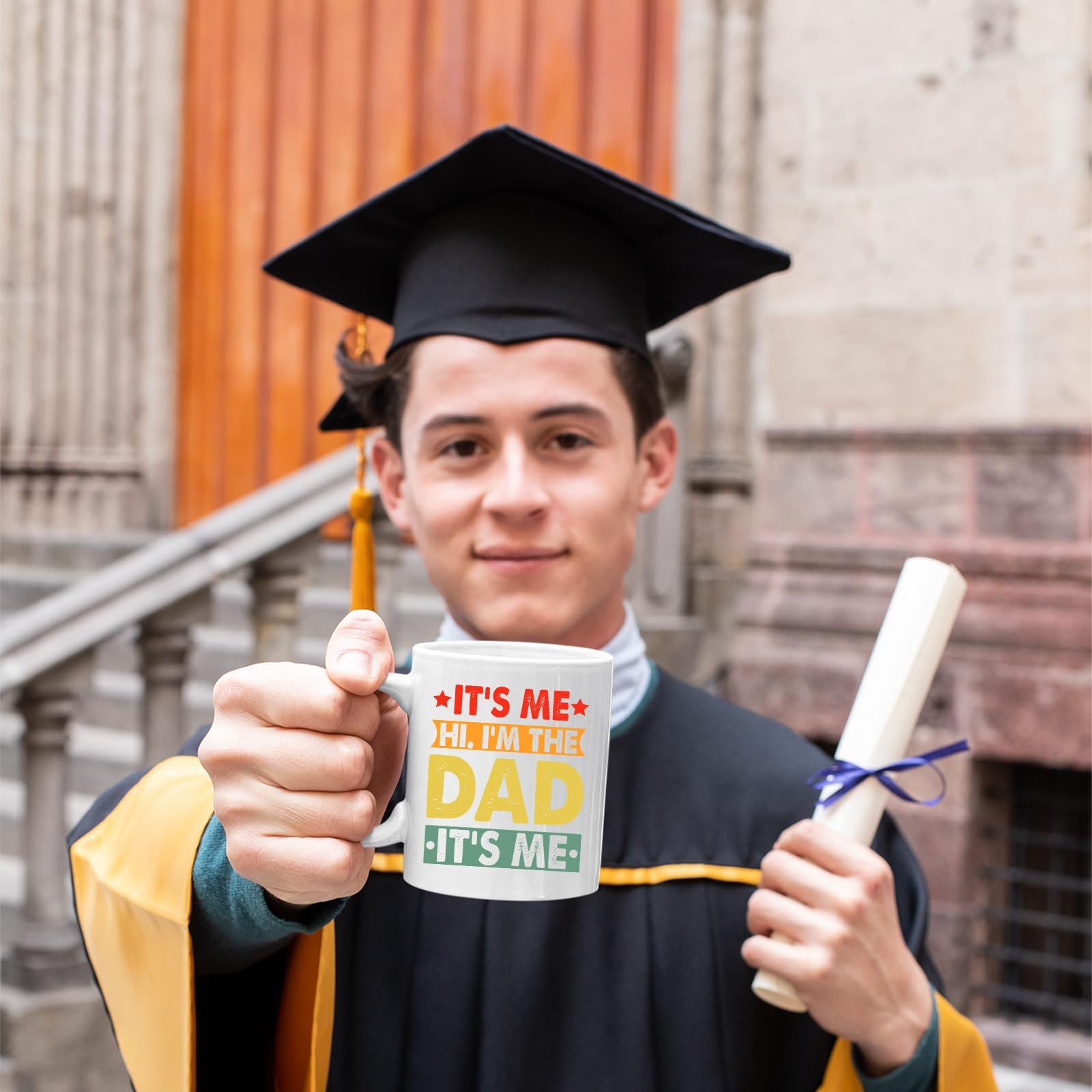 71 zbpndxll.jpg Graduate in cap and gown holding the It’s Me Hi I’m the Dad mug