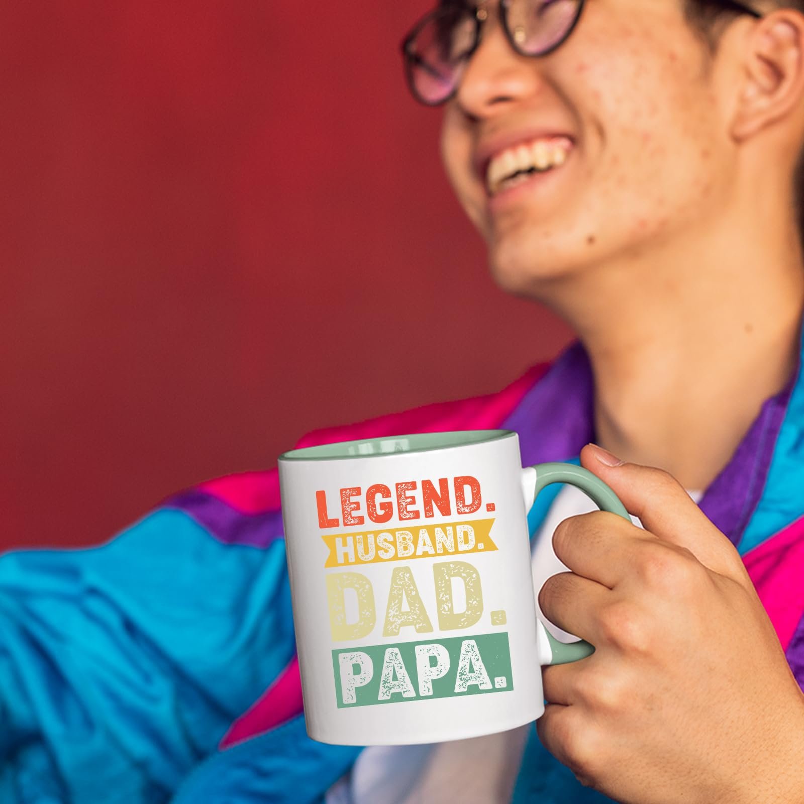 714wefjvrrl.jpg Smiling person in a colourful jacket holding the Legend Husband Dad Papa mug with a light green handle