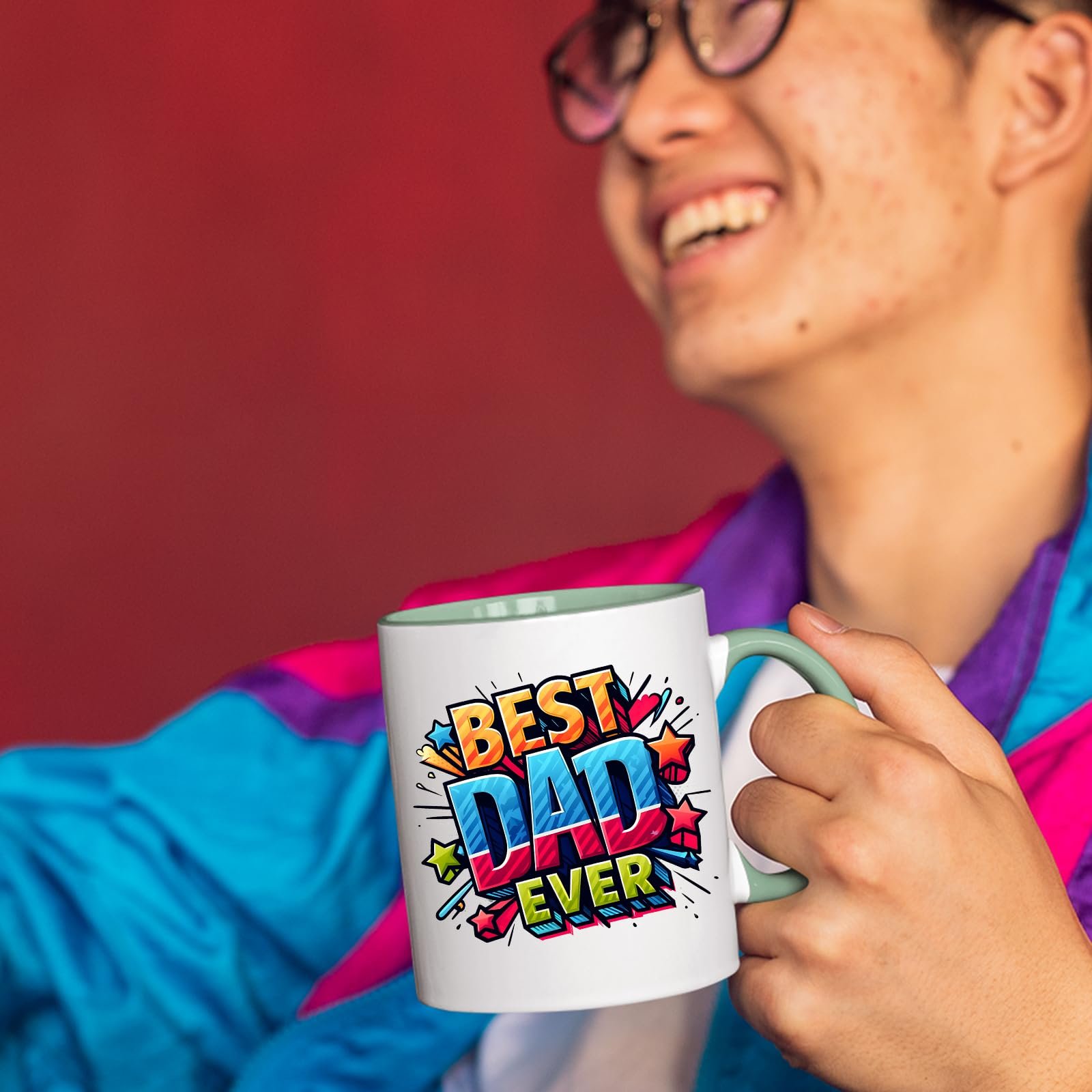 71cx5iucfil.jpg Smiling person in a colourful jacket holding the Best Dad Ever comic mug with a light green handle