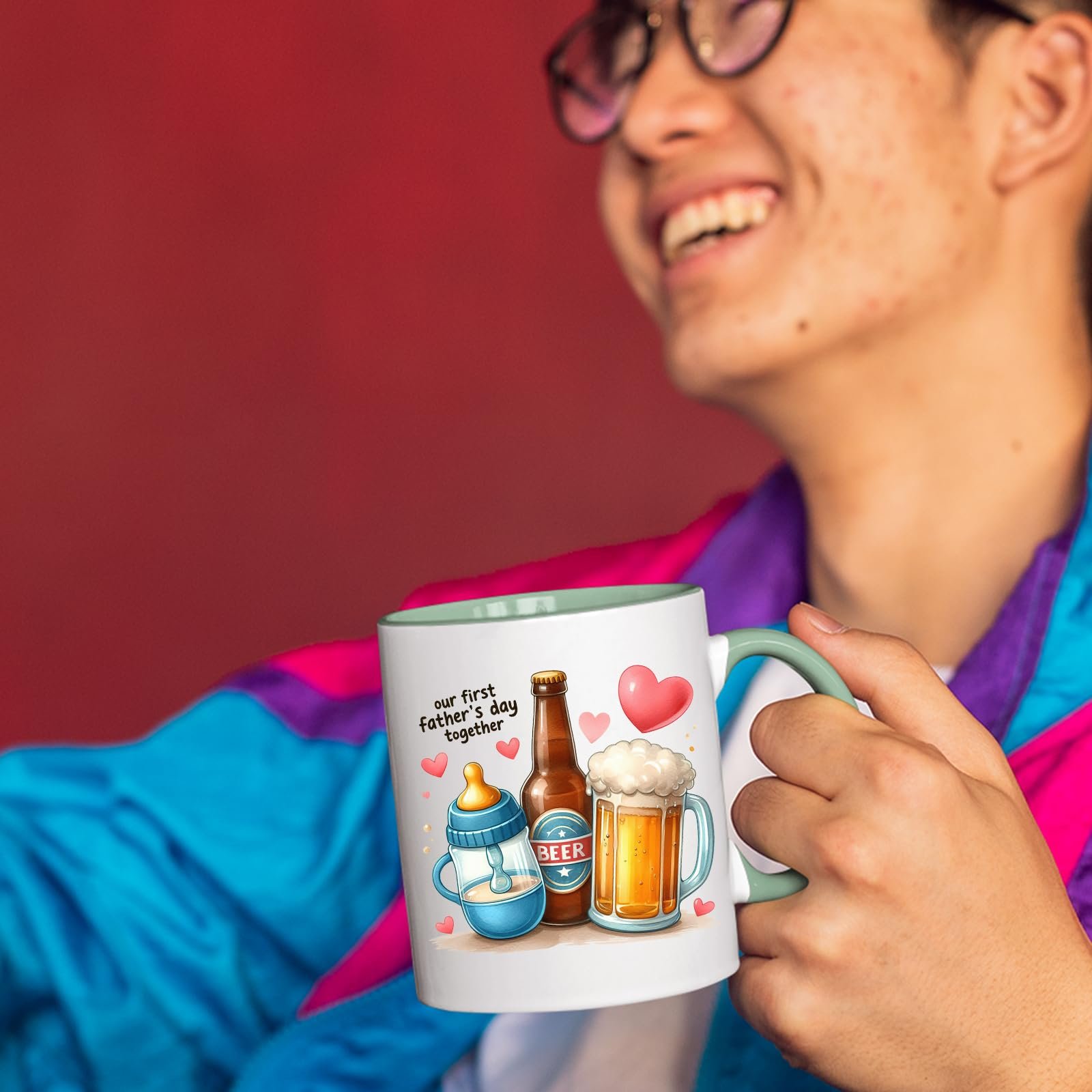 71fz6jnvwdl.jpg Smiling person in a colourful jacket holding the First Father’s Day hearts mug with a light green handle