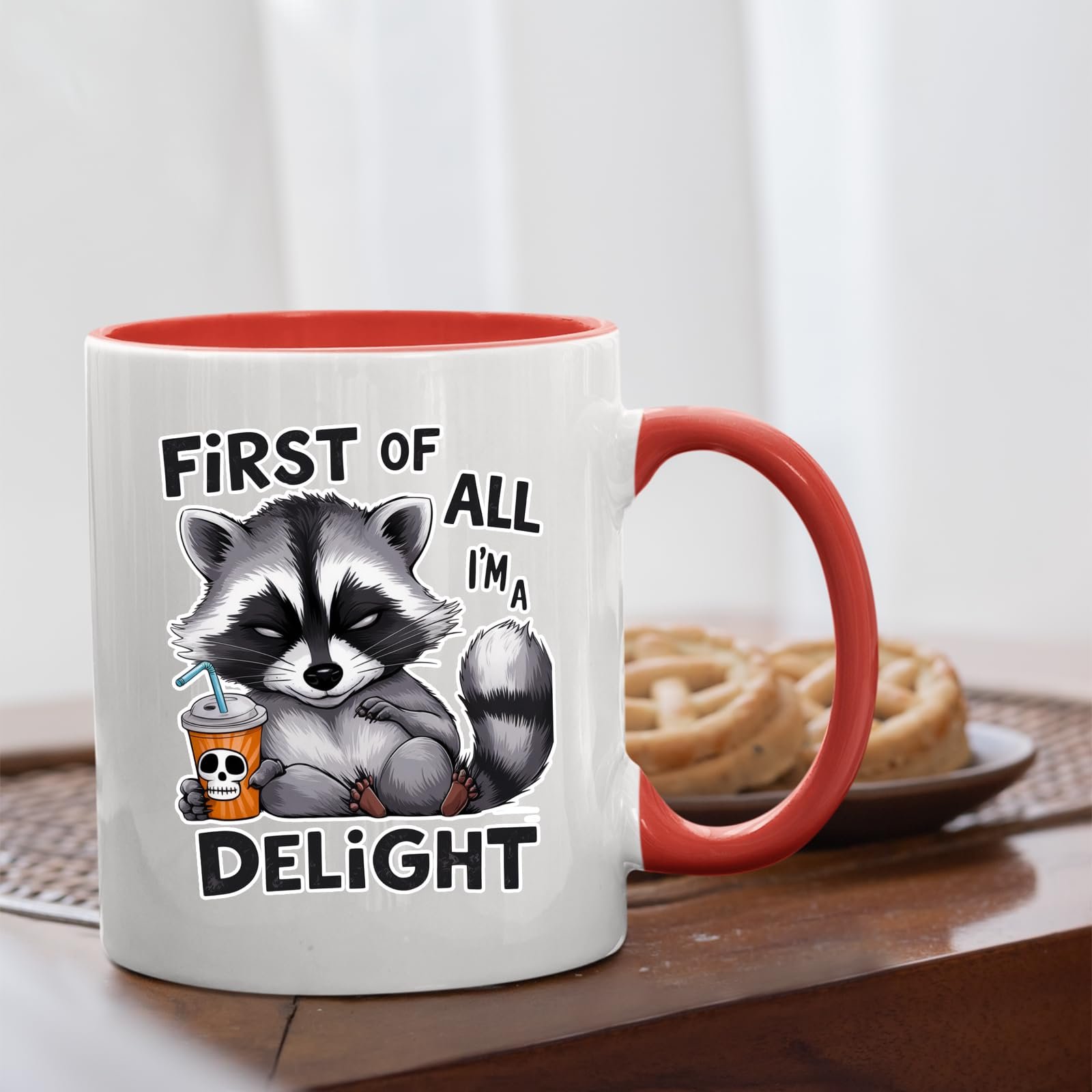 71ibfcpk4xl.jpg First of All I’m a Delight raccoon mug with a red handle beside biscuits