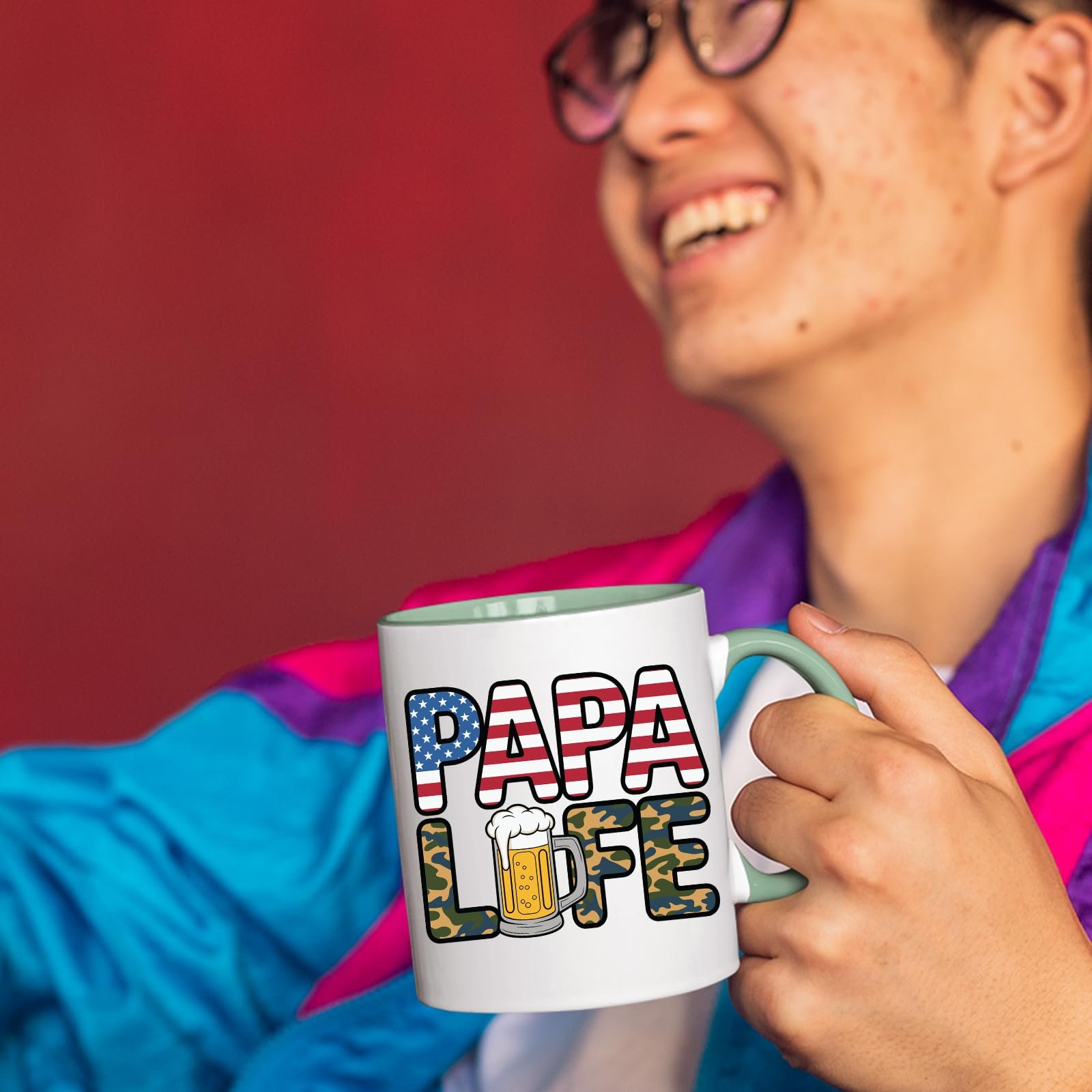 71kfuqg8val.jpg Smiling person in a colourful jacket holding the Papa Life mug with a light green handle