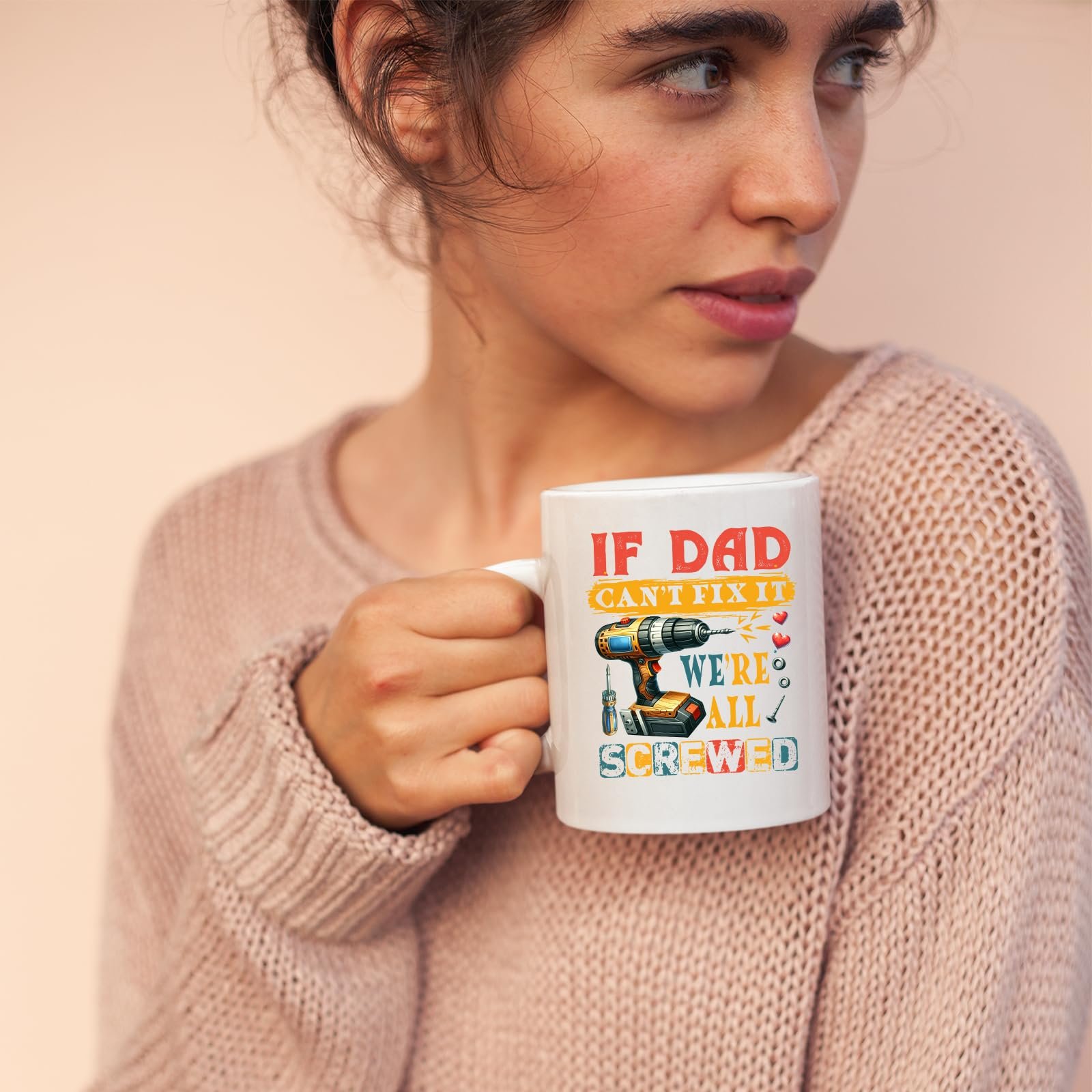 71m 61pci l.jpg Woman in a pink jumper holding the If Dad Can’t Fix It mug