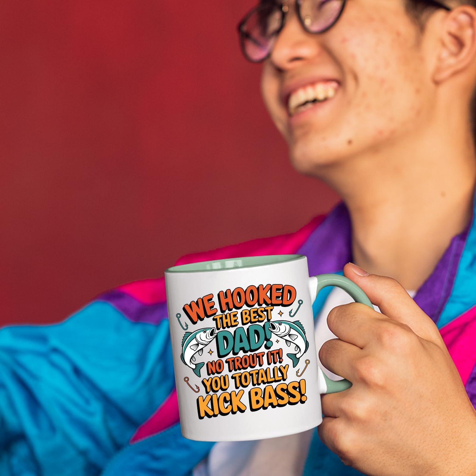 71scn8 daal.jpg Smiling person in a colourful jacket holding the We Hooked the Best Dad mug with a light green handle