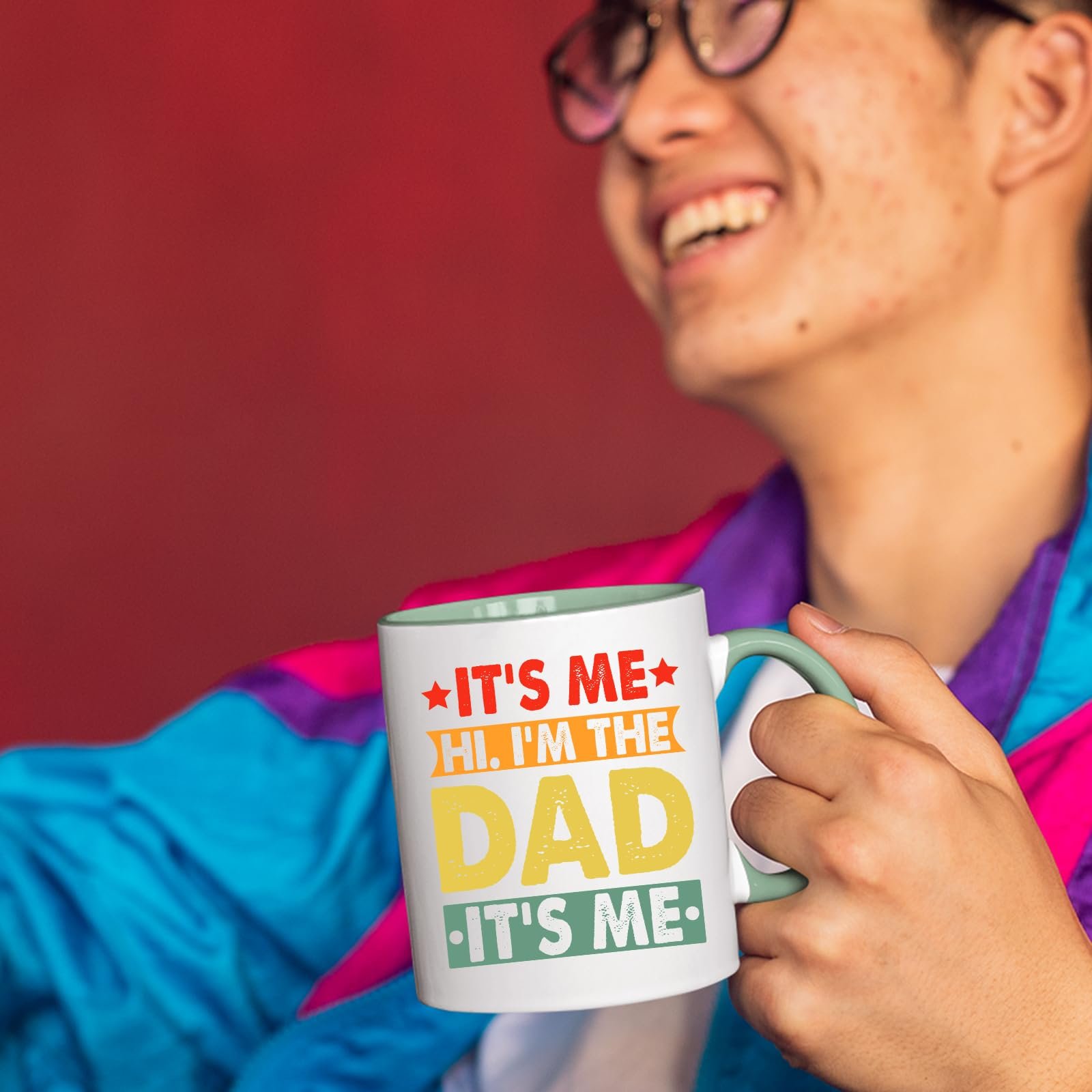 71sm iiidal.jpg Smiling person in a colourful jacket holding the It’s Me Hi I’m the Dad mug with a light green handle