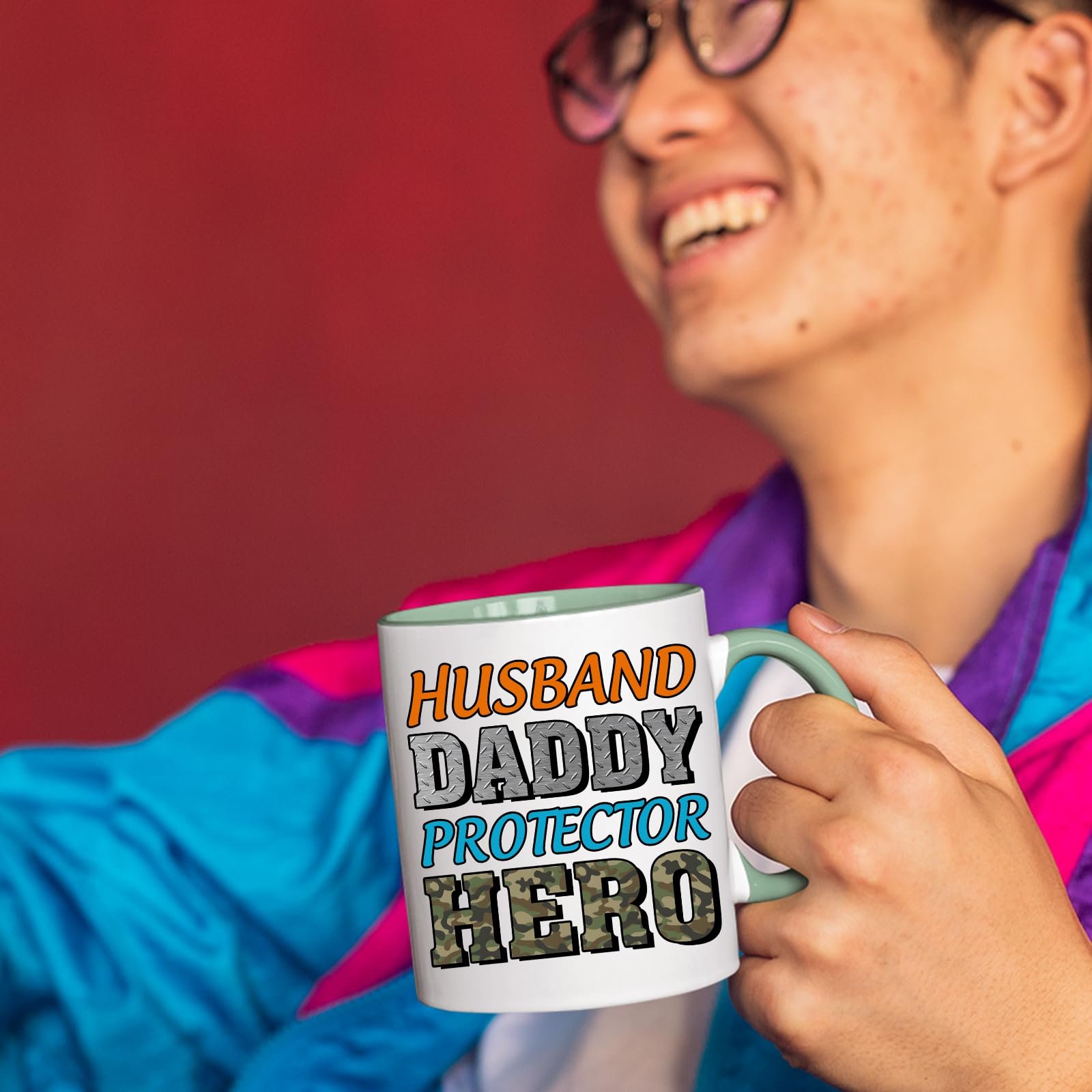 71tqvez7wel.jpg Smiling person in a colourful jacket holding the Husband Daddy Protector Hero camo mug with a light green handle