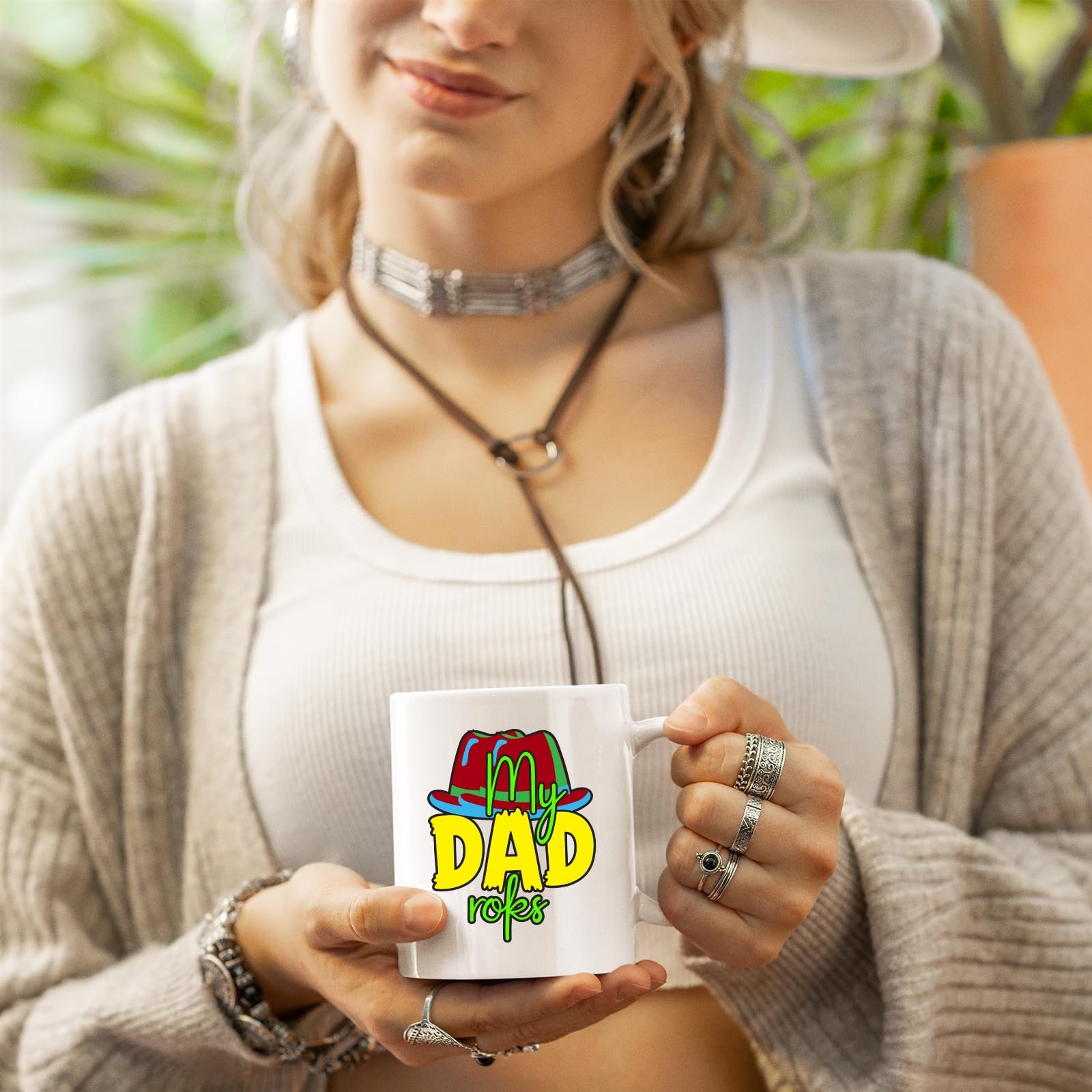 71vlkw6btvl.jpg Woman in a cardigan holding a white mug with the colourful My Dad Rocks hat design