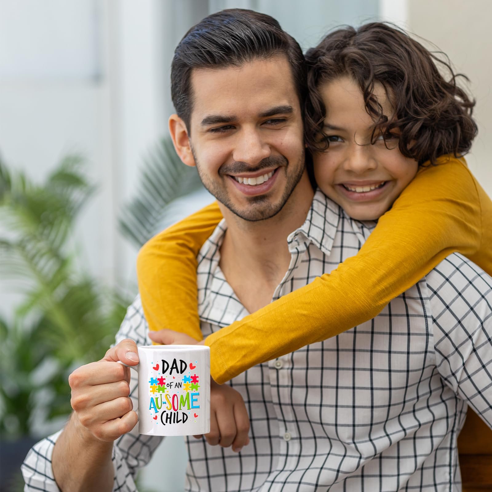 71vv2w3gydl.jpg Smiling dad holding the Dad of an Au-Some Child mug as his son hugs him