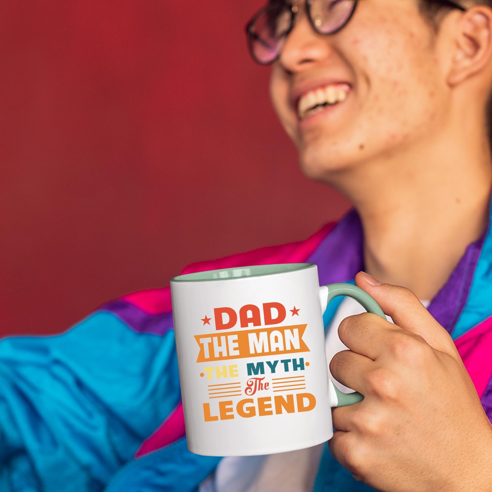 71dvt5 5ynl.jpg Smiling person in a colourful jacket holding the Dad the Man retro mug with a light green handle