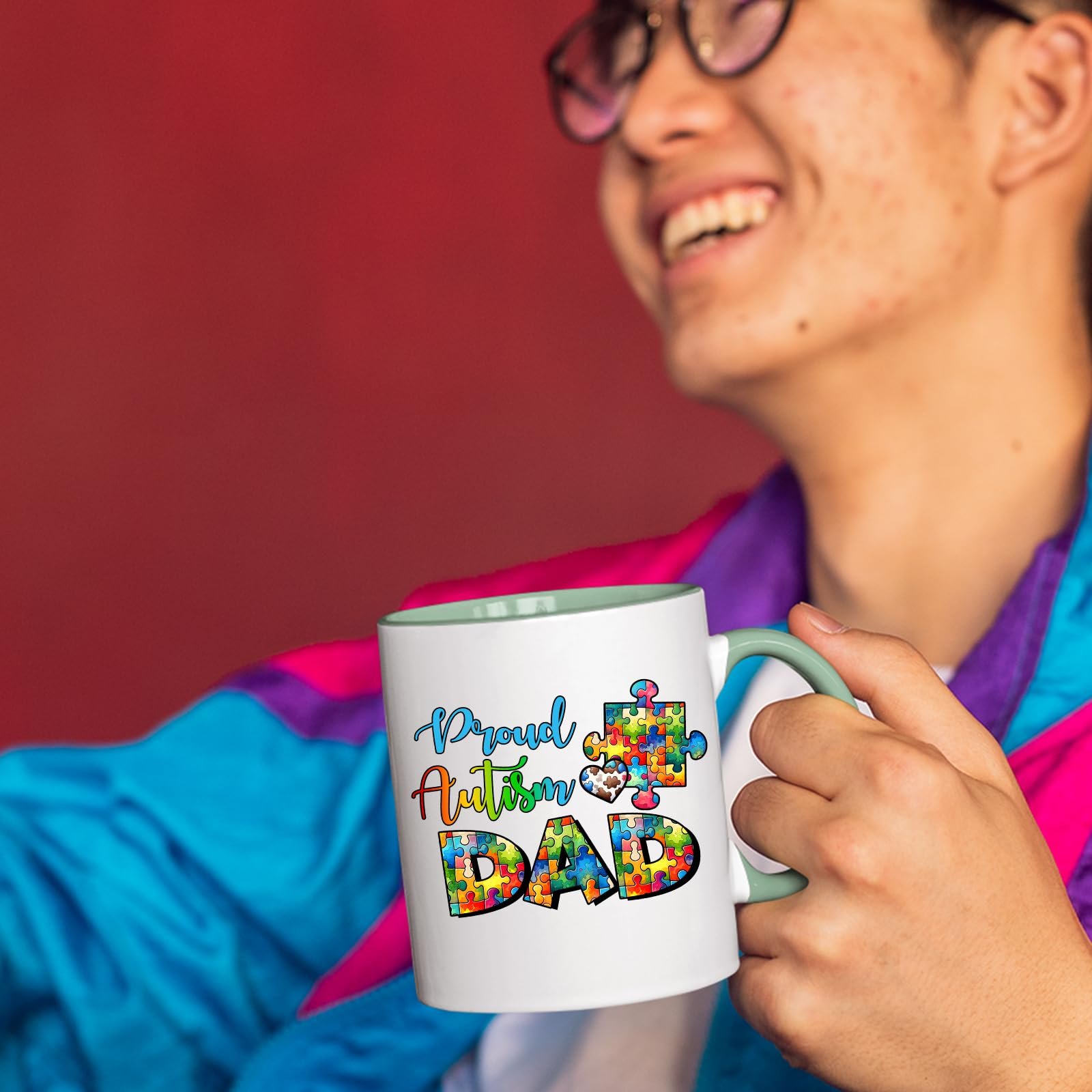 71saz5 b tl.jpg Smiling person in a colourful jacket holding the Proud Autism Dad mug with a light green handle
