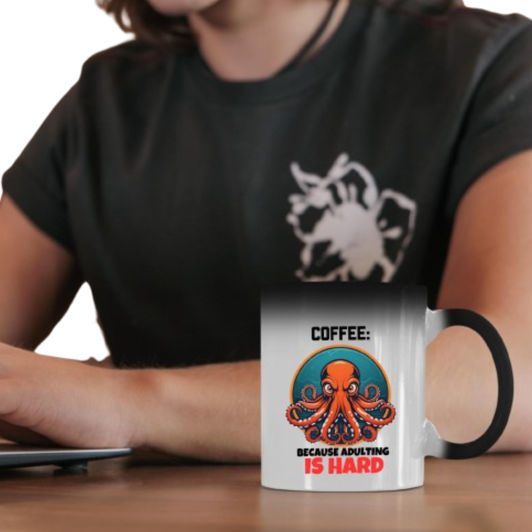 untitleddesign 2 82165721 b608 4892 b769 cbeb6555e20a.png Person holding the colour changing mug with a grumpy octopus and “Coffee: Because Adulting Is Hard”