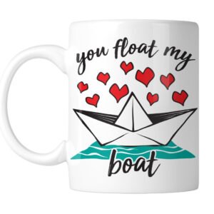 White mug with a paper boat, red hearts and “You Float My Boat”, handle on the left