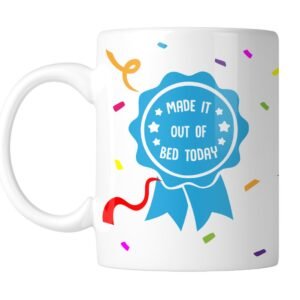 White mug with a blue award rosette that reads “Made It Out of Bed Today”, handle on the left