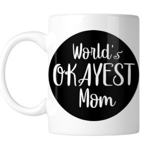 White mug with “World's Okayest Mom” in white on a black circle, handle on the left